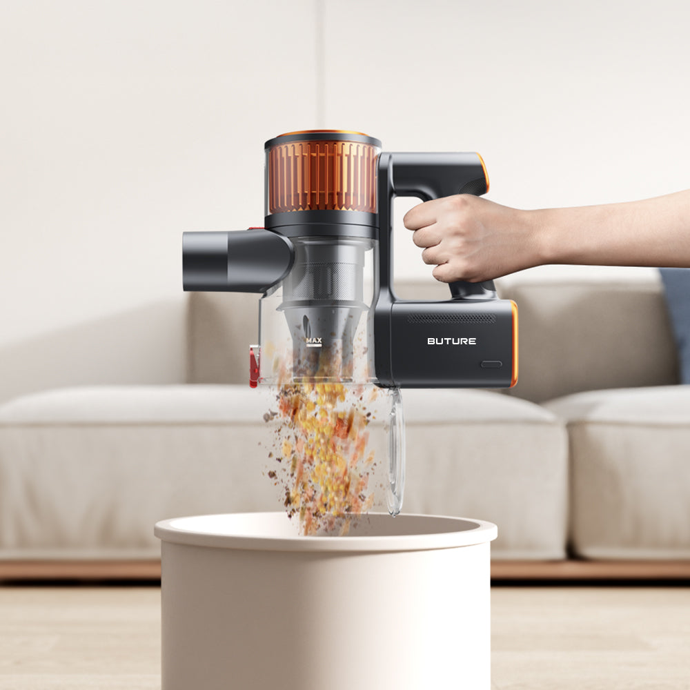 Hand using Buture X9 cordless vacuum cleaner to one-click empty large dust cup into trash can.